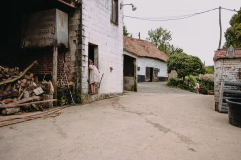 A person stands at the door of a farm building at Feather Down Fermette des trois tilleuls in Hauts-de-France.