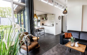 Moderne Z Module Lodge im Landgoed de Scheleberg, Niederlande, mit stilvoller Einrichtung und großen Fenstern.