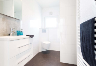 Baño moderno y luminoso en Z Module de Landgoed de Scheleberg, Países Bajos, con inodoro suspendido blanco.