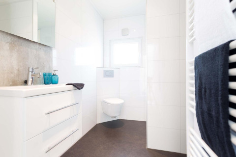 Baño moderno y luminoso en Z Module de Landgoed de Scheleberg, Países Bajos, con inodoro suspendido blanco.