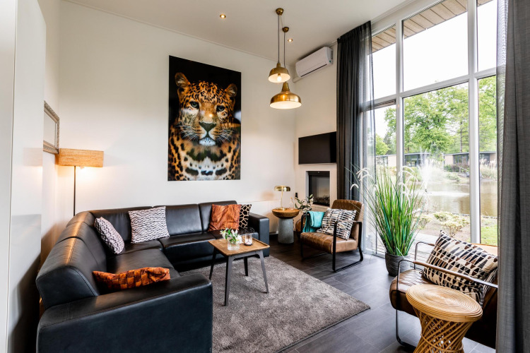 Salón luminoso y moderno en la cabaña Z Module de Landgoed de Scheleberg, Países Bajos, con arte de leopardo.