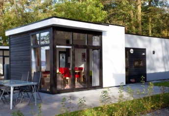 Cube la Mer 4 lodge te Schoneveld, Nederland, met grote ramen en terras in een bosrijke omgeving.