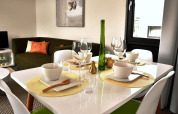 Modern gedekte eettafel en groen bankstel in Cube la Mer 4 lodge op Schoneveld, Nederland.