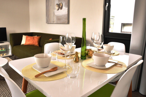Table à manger moderne avec canapé vert dans le lodge Cube la Mer 4 à Schoneveld, Pays-Bas.