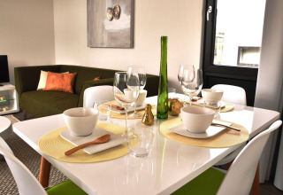 Table à manger moderne avec canapé vert dans le lodge Cube la Mer 4 à Schoneveld, Pays-Bas.