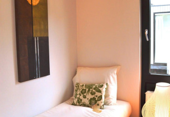 Cozy bedroom in Cube la Mer 4 at Schoneveld, Netherlands, with a single bed, pillow, art, and a lamp.