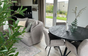 Modern living room in Just Nature Light lodge at Marina Strandbad, Netherlands, with cozy seating and garden view.