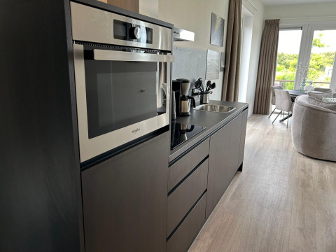 Cocina moderna con horno y cafetera en Just Nature Light Lodge en Marina Strandbad, Países Bajos.