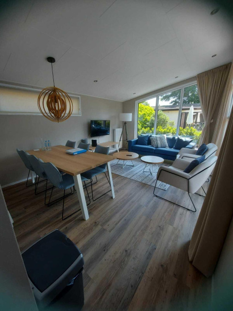 Moderne leef- en eetruimte in de Deluxe Sauna cabin bij EuroParcs Noordwijkse Duinen, Nederland.