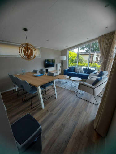 Sala y comedor modernos en la cabaña Deluxe Sauna en EuroParcs Noordwijkse Duinen, Países Bajos.