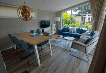 Espace salon et salle à manger moderne dans le chalet Deluxe Sauna à EuroParcs Noordwijkse Duinen, Pays-Bas.