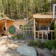 Hobbit House 1, et lille hus inspireret af Ringenes Herre, ligger i en skov med grøn dør og runde vinduer.