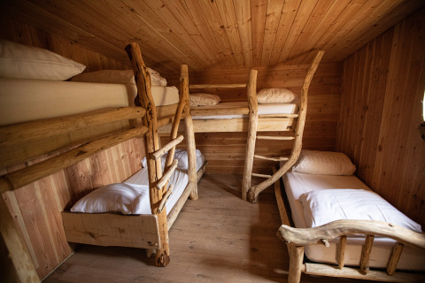 Habitación acogedora en Hobbit House 1 con cuatro literas de madera rústica en Cosy Cabins, bosque de Limburg, Bélgica.
