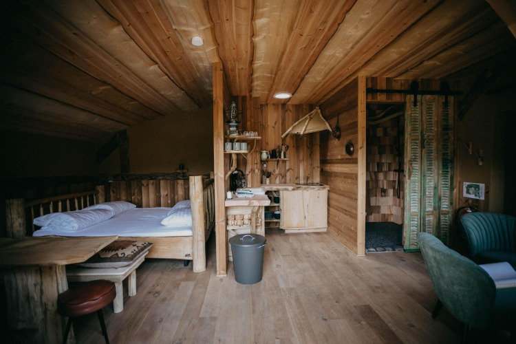 Acogedor interior de madera en Hobbit House 1 de Cosy Cabins, en el bosque de Limburg, Bélgica.