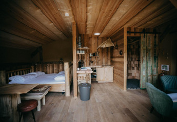 Acogedor interior de madera en Hobbit House 1 de Cosy Cabins, en el bosque de Limburg, Bélgica.