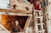 Dos niños juegan en una habitación de literas de madera en Hobbit House en Cosy Cabins, bosque de Limburg, Bélgica.