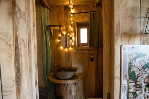 Gemütliches Badezimmer im Hobbit House bei Cosy Cabins, Limburg-Wald, Belgien, mit rustikaler Holzverkleidung.