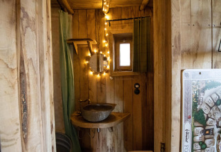 Gemütliches Badezimmer im Hobbit House bei Cosy Cabins, Limburg-Wald, Belgien, mit rustikaler Holzverkleidung.