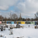 Kleurrijke tiny houses in de sneeuw bij Valley Chalet, Holiday park Ackersate, Nederland, speeltuin vooraan.