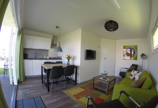 Modern living area and kitchen inside the Valley Chalet tiny house at Holiday park Ackersate, Netherlands.