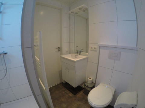 Baño moderno en Valley Chalet en Holiday park Ackersate, Países Bajos, con ducha, lavabo y aseo.