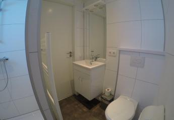 Modernes Badezimmer im Valley Chalet im Holiday Park Ackersate, Niederlande, mit Dusche, Waschbecken und WC.