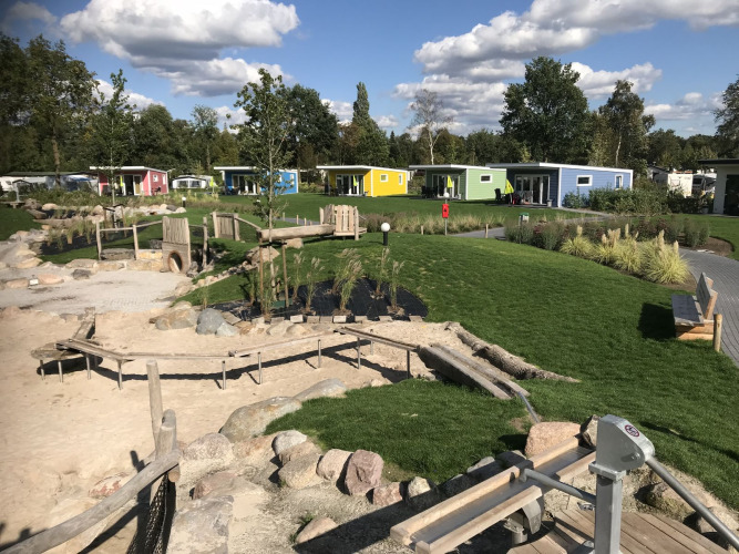 Kleurrijke tiny houses bij Valley Chalet, Holiday park Ackersate in Nederland, met speeltuin en grasveld.