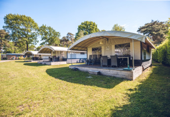 Safari-Zeltvillen im Ferienpark Ackersate in den Niederlanden, mit Holzterrasse und grüner Umgebung.