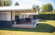 Safari-Zeltvilla im Ferienpark Ackersate in den Niederlanden mit Veranda und Garten im Sonnenschein.