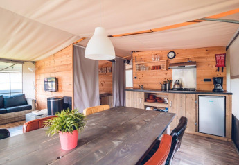 Interieur van een luxe safaritentvilla met houten inrichting op Vakantiepark Ackersate in Nederland.