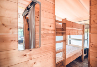 Interno in legno con letti a castello in una tenda safari Tentvilla presso Holiday park Ackersate nei Paesi Bassi.