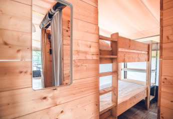 Interno in legno con letti a castello in una tenda safari Tentvilla presso Holiday park Ackersate nei Paesi Bassi.