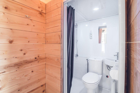 Badezimmer in einem Safarizelt im Holiday Park Ackersate, Niederlande mit WC, Dusche und Waschbecken.