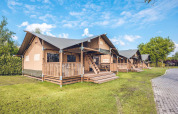 Tenda safari 'Red Deer' presso Holiday park Ackersate nei Paesi Bassi, veranda in legno, prato, giornata soleggiata.