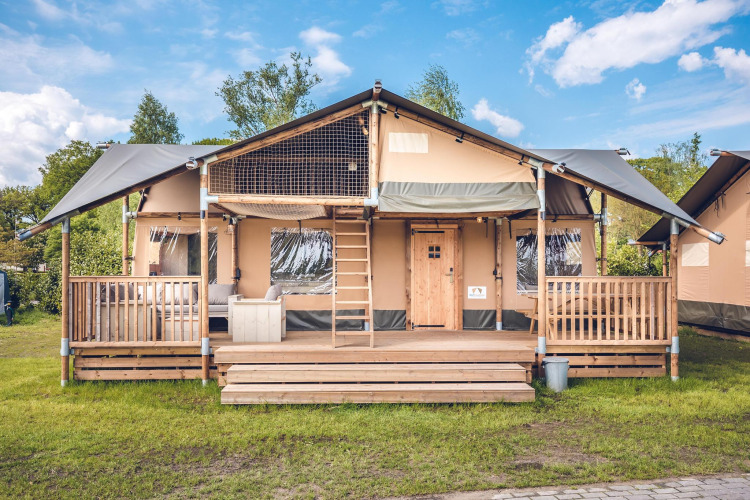 Safaritent 'Red Deer' op Vakantiepark Ackersate in Nederland, met houten veranda en trap.