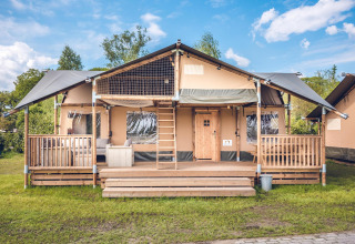 Safaritent 'Red Deer' op Vakantiepark Ackersate in Nederland, met houten veranda en trap.