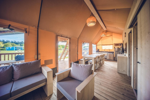 Interior view of Safari tent 'Red Deer' at Holiday park Ackersate in the Netherlands with wood furniture.