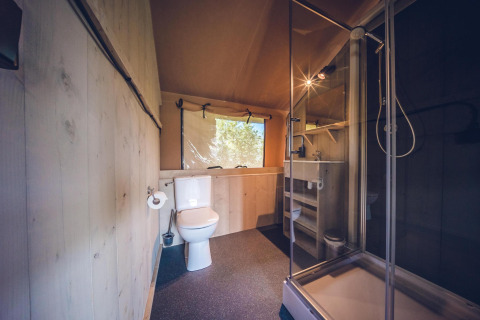 Badkamer in safaritent 'Red Deer' op vakantiepark Ackersate in Nederland met douche en toilet.