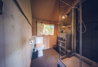Badkamer in safaritent 'Red Deer' op vakantiepark Ackersate in Nederland, met douche en toilet.