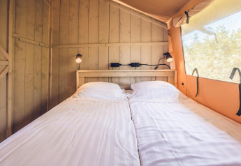 Interieur van safaritent 'Red Deer' met twee eenpersoonsbedden bij Holiday park Ackersate in Nederland.
