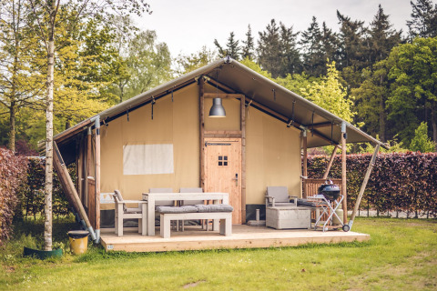 Safari-Zelt 'Vos' im Ferienpark Ackersate in den Niederlanden mit Terrassenmöbeln und Grill.