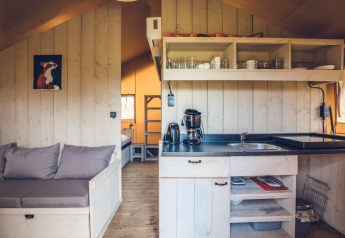 Interior of Safari tent 'Vos' at Holiday park Ackersate, Netherlands, with kitchen and seating area.