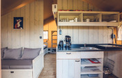Interieur van safaritent 'Vos' op vakantiepark Ackersate in Nederland, met keuken en zithoek.