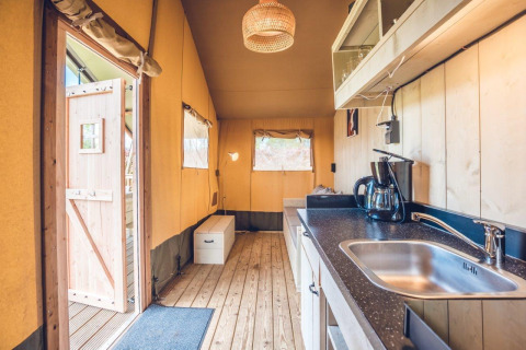 Interior view of Safari tent 'Vos' at Holiday park Ackersate, Netherlands, featuring a cozy kitchen and seating.