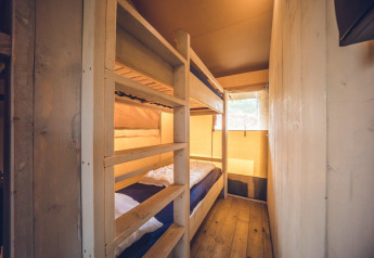 Interno della tenda safari 'Vos' al Holiday park Ackersate, Paesi Bassi, con letti a castello e pareti in legno.
