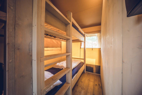 Indvendigt billede af Safari telt 'Vos' på Holiday park Ackersate, med køjesenge og trævægge.