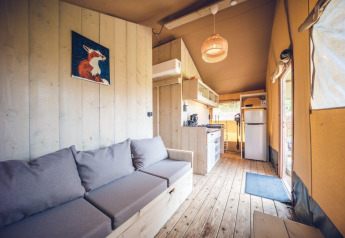 Safaritent 'Vos' op vakantiepark Ackersate in Nederland, houten interieur, keuken en zitgedeelte.