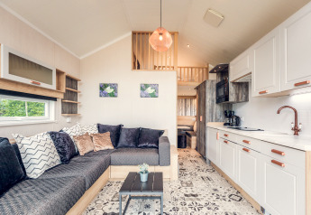 Modern tiny house interior at Holiday Park Ackersate in the Netherlands, featuring a kitchen and cozy living area.
