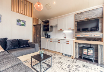 Licht en modern tiny house interieur op Holiday park Ackersate in Nederland, met bank en kitchenette.