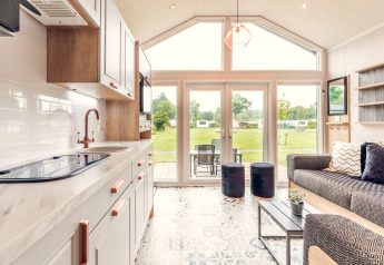 Intérieur d'une tiny house moderne au Holiday park Ackersate, Pays-Bas, avec vue sur le jardin verdoyant.
